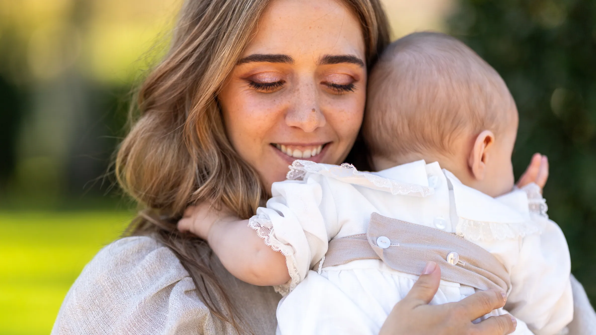 Mãe a sorrir com o bebé ao colo