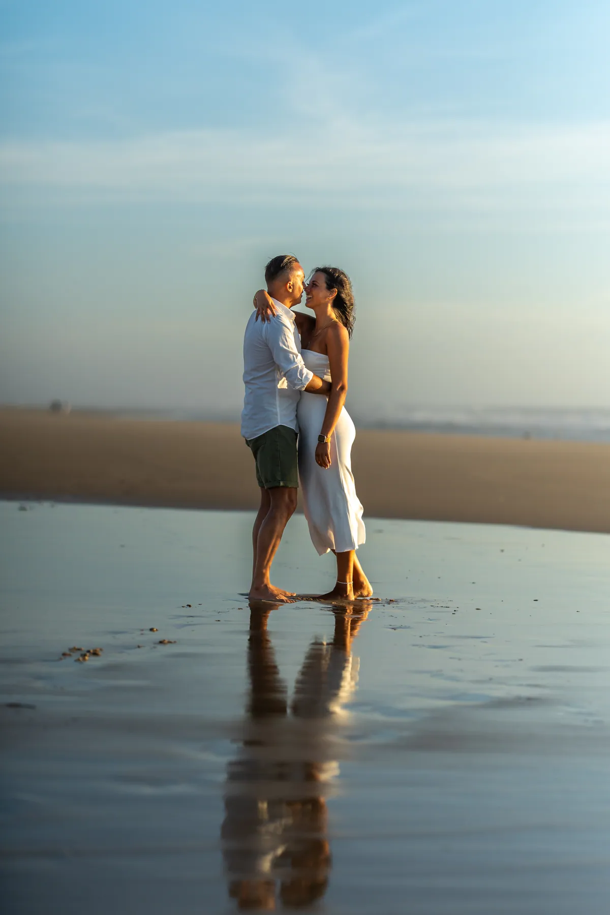 Casal abraçado na praia ao entardecer