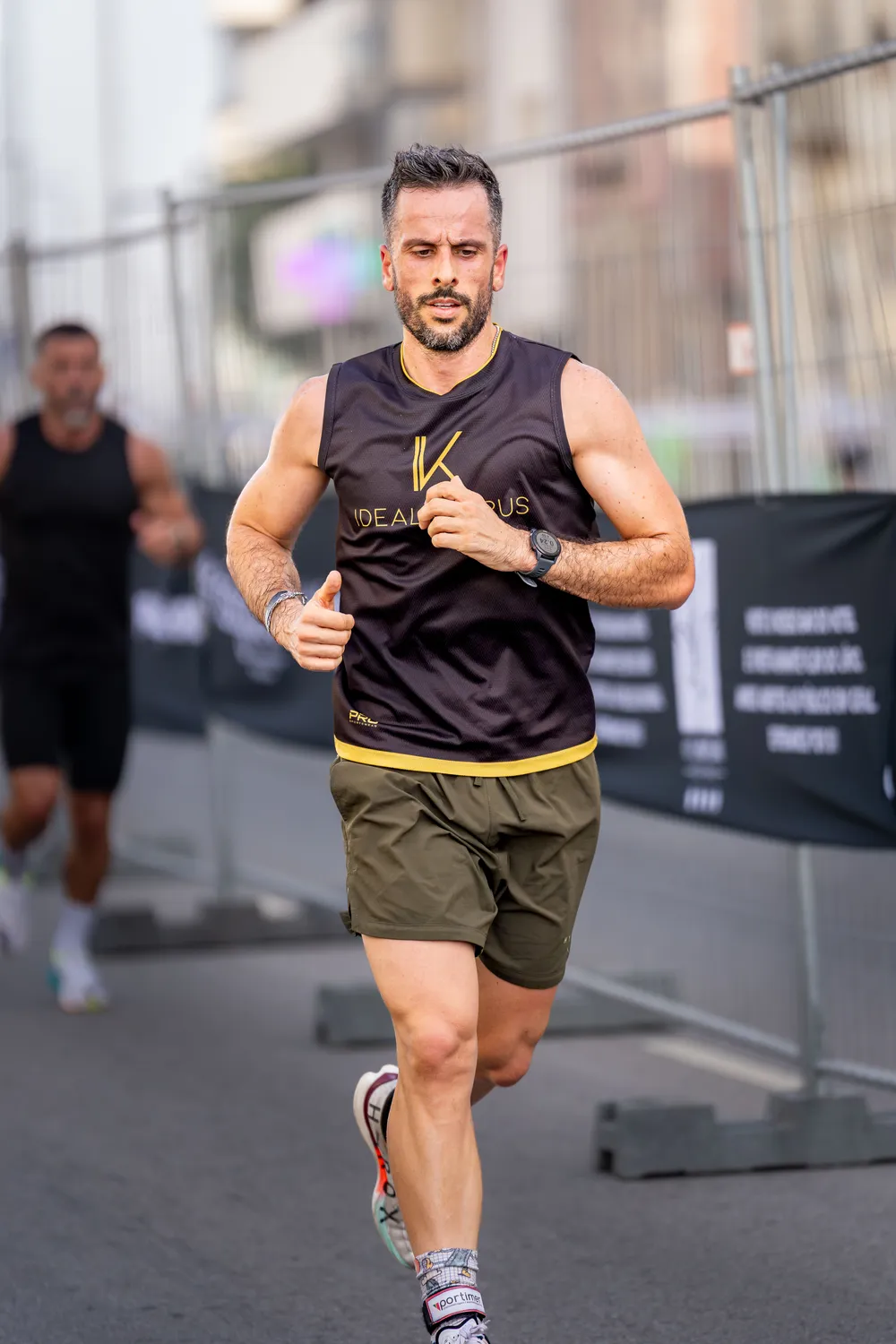 Atleta a correr numa prova de rua, concentrado