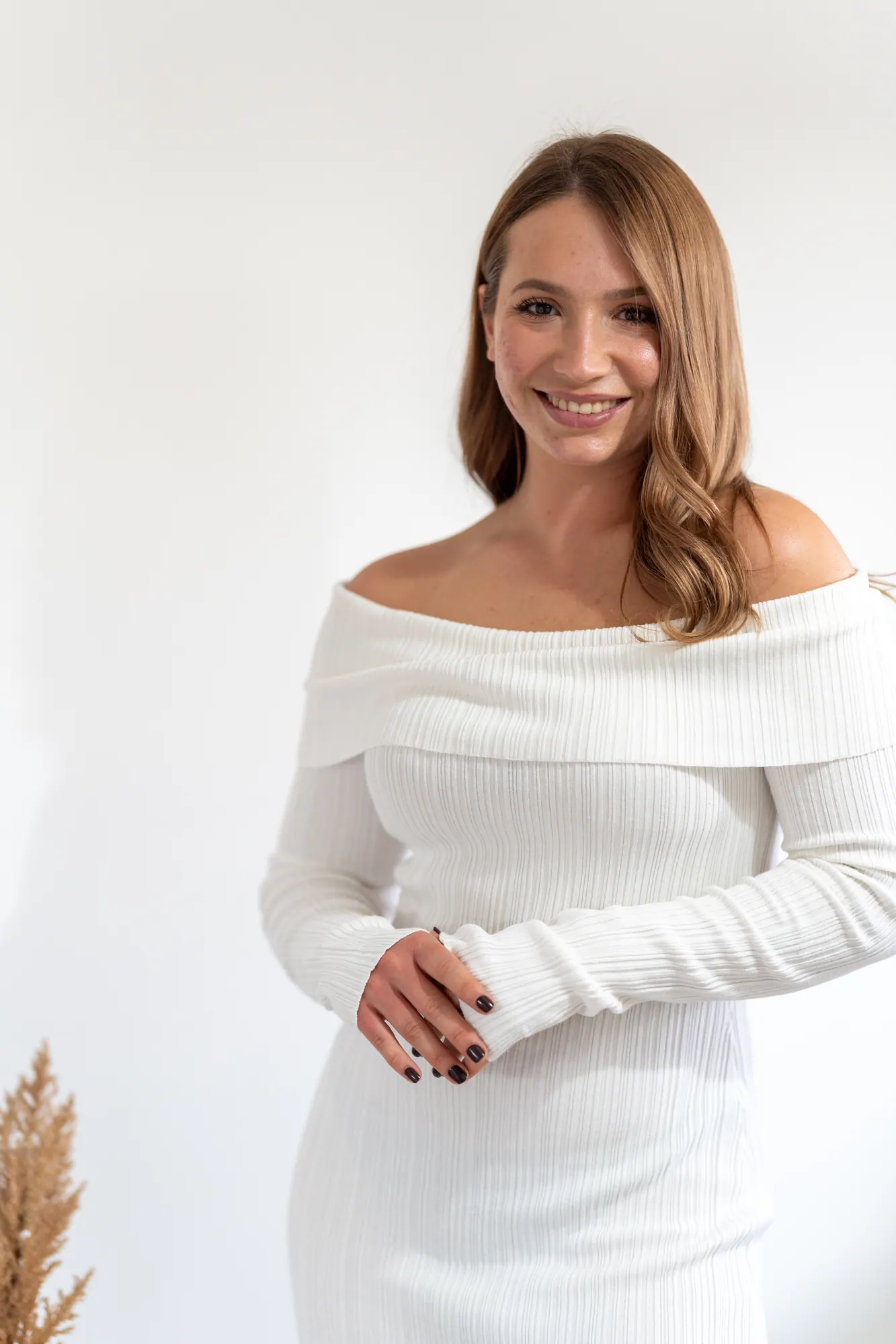 Retrato de mulher a sorrir, de blusa branca, em luz natural quente